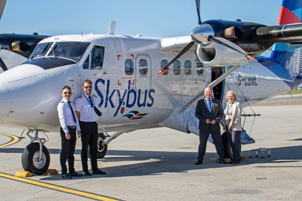 2 pilots standing in front of a Skybus twin otter at Cornwall Airport Newquay 