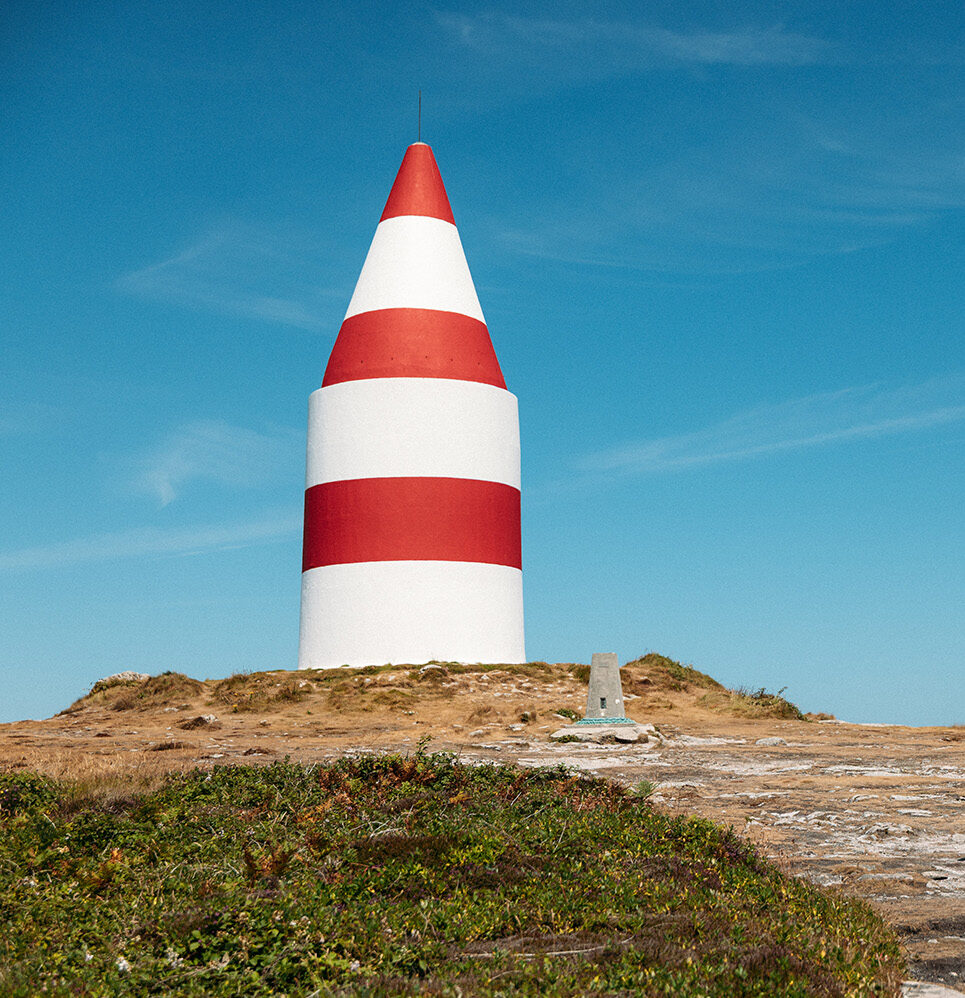 The iconic red-and-white Daymark standing proudly on St Martin’s under blue skies.